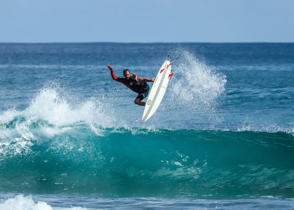 young man doing tricks while surfing in the ocean